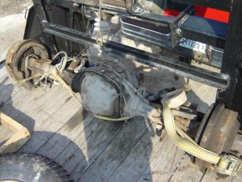 1992 Ford Bronco - A rear axle assembly, likely from a truck or SUV, is secured with yellow straps on a wooden surface.