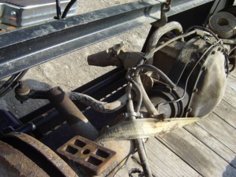 1992 Ford Bronco - Front axle assembly with suspension components and differential housing, suspended by straps.