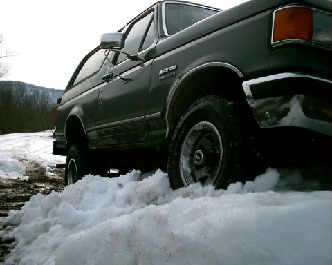 1988 Ford Bronco - This 1988 Ford Bronco navigates a snowy terrain, showing its robust off-road capability.