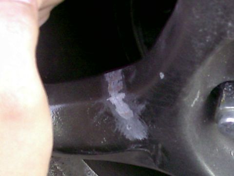 1997 Ford Probe - A close-up view of a vehicle's suspension component shows some white residue and scuff marks.