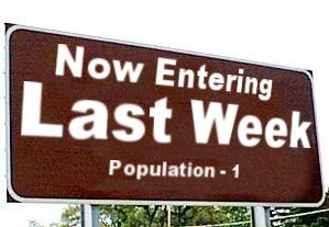 1968 Ford Mustang - A brown highway-style road sign reading "Now Entering Last Week, Population - 1" in white lettering, mounted on posts against a background…