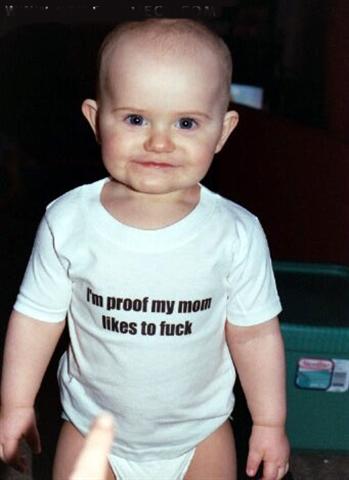 1968 Ford Mustang - A baby wearing a white t-shirt with text stands in front of a dark background.