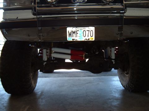 1989 Ford Bronco - The front suspension of a 1989 Ford Bronco features dual shocks and a stabilizer bar, with an Oregon license plate visible.
