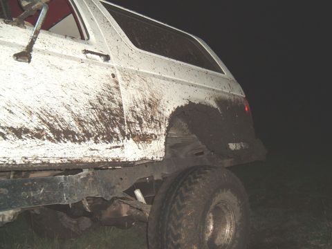 1989 Ford Bronco - Mud-splattered white SUV seen from the side at night.