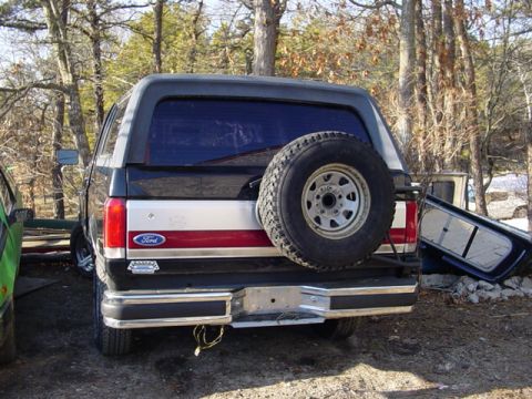 1989 Ford Bronco - Rear view of a 1989 Ford Bronco showing its spare tire and distinctive red and silver stripe.