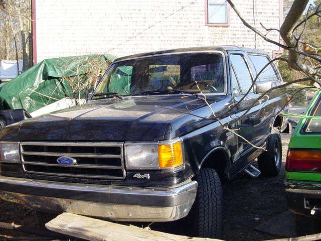 Black Ford Bronco with chrome grille and 4x4 badge, parked outdoors