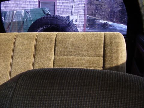 1989 Ford Bronco - The interior of a 1989 Ford Bronco shows the rear seat and a spare tire mounted behind it.