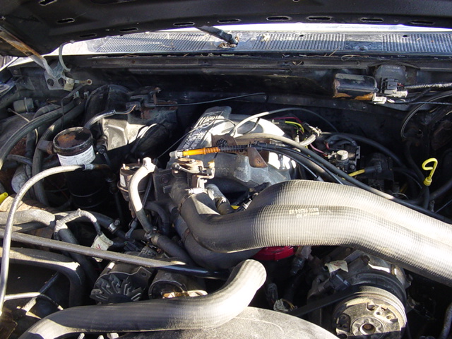 Engine bay view showing intake tubing, radiator and accessory components under hood