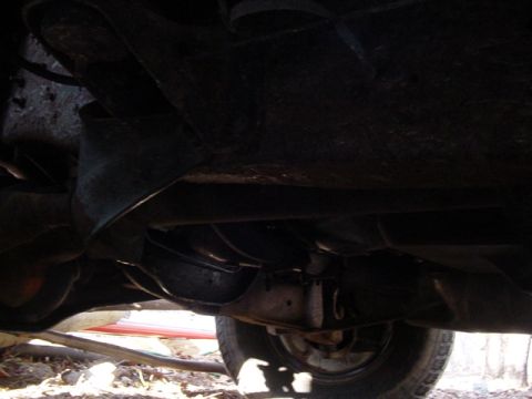 1989 Ford Bronco - The underside of a vehicle is visible, showing exhaust and suspension parts.