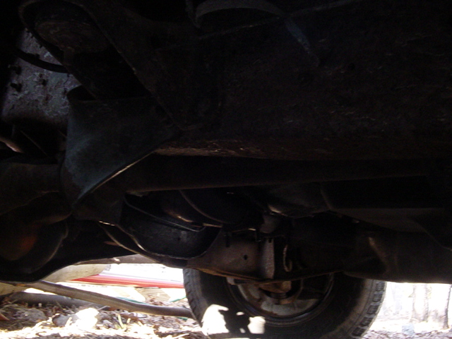 Undercarriage view of a vehicle with visible exhaust pipes and suspension components