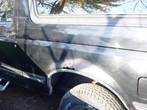 1989 Ford Bronco - This Bronco shows significant rust damage on its rear quarter panel, indicating a need for repair.