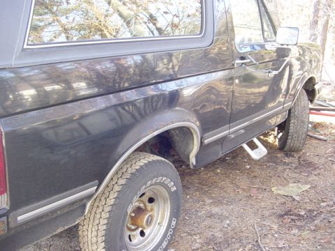 1989 Ford Bronco - This black Ford Bronco shows a side profile with visible chrome trim and running boards.
