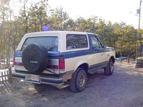 1989 Ford Bronco - This 1989 Ford Bronco features a two-tone blue and white paint scheme and a rear-mounted spare tire.
