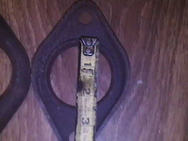 Close-up of an exhaust flange with a tape measure showing about 1.5 inches