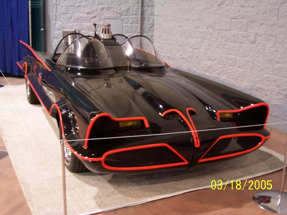 Black custom car with red trim, dual bubble windshields, and fins