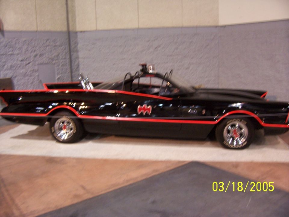Black Batmobile replica with red trim and bat symbols on doors