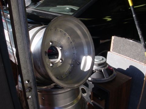 1989 Ford Bronco - Several car rims and audio speakers are piled up in what appears to be a storage area.
