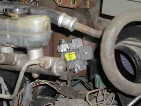 1988 Ford Bronco - Close-up view of vehicle's brake master cylinder and an electronic component with wiring.