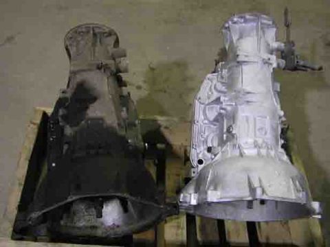 1988 Ford Bronco - A dirty transmission is compared to a clean one, both resting on wooden pallets.