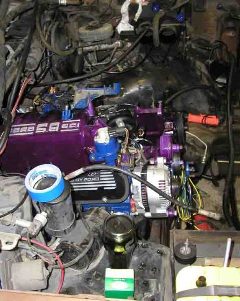 1988 Ford Bronco - Close-up view of a Ford engine with custom purple valve covers and various engine components.