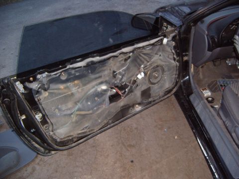 1993 Ford Probe - The interior of a 1993 Ford Probe shows exposed wiring and a speaker after the door panel has been removed.