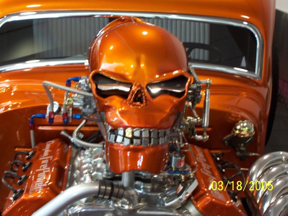 Orange hot rod engine with a chrome skull cover and visible plumbing. Date stamp reads 03/18/2005