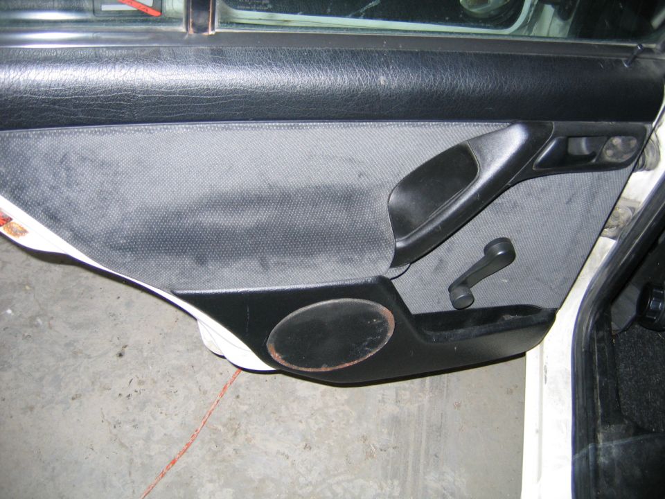 Interior door panel with manual window crank and speaker grille
