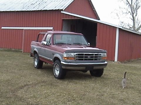 1994 Ford Bronco - This two-tone 1994 Ford Bronco is parked outside a red barn on a grassy field.
