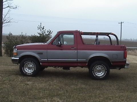 1994 Ford Bronco - This two-tone Ford Bronco is shown from the side, parked outdoors on a cloudy day.