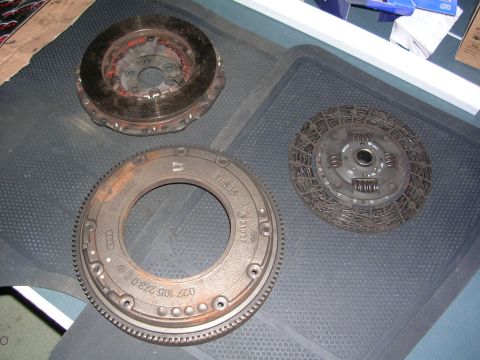 2003 Chevrolet Monte Carlo - Clutch disc and flywheel assembly parts are laid out on a textured mat.