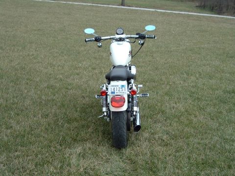 1995 Mercury Grand Marquis - A white motorcycle is shown from the rear, parked on a grassy field.