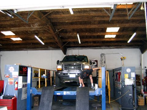 2000 Ford Crown Victoria - A person works on a Ford F-Series truck positioned on a dynamometer in a workshop.