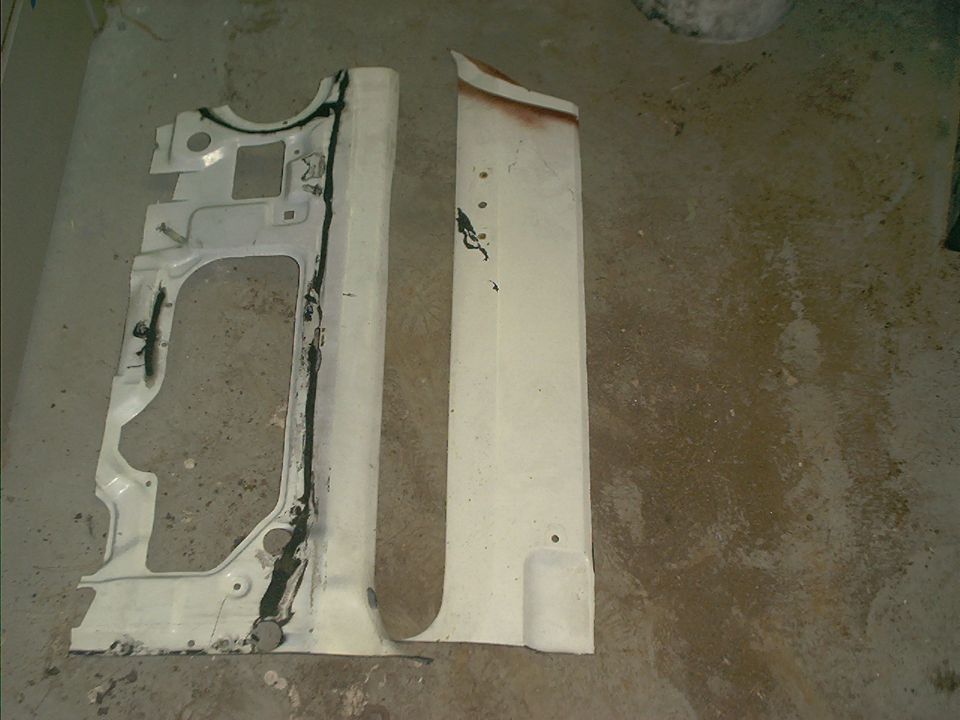 Two white sheetmetal body panels with seam sealer laid on a concrete floor