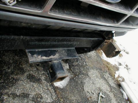 1995 Ford Bronco - The rear bumper and trailer hitch assembly of a Ford truck are visible in this low-angle shot.