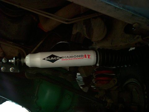 1988 Ford Bronco - Close-up of a Black Diamond AT shock absorber, part of the vehicle's suspension system.
