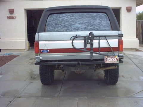 1990 Ford Bronco - The rear of a silver 1990 Ford Bronco is visible, equipped with a spare tire carrier and an Arizona license plate.