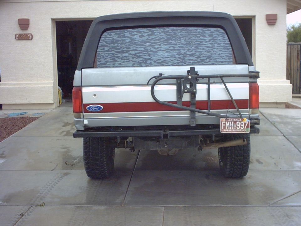 Silver 1990 Ford Bronco rear view with spare tire carrier and Arizona license plate FMH:997