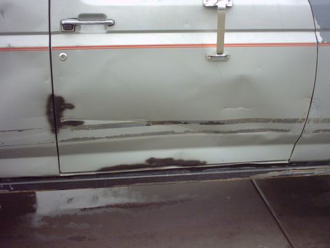 1990 Ford Bronco - This 1990 Ford Bronco shows significant rust and damage on its side door.