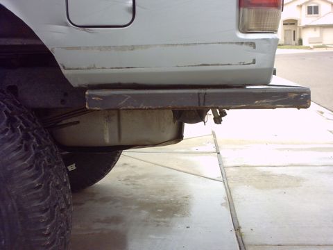 1990 Ford Bronco - Close-up of a vehicle's rear bumper and tire, showing wear and tear.