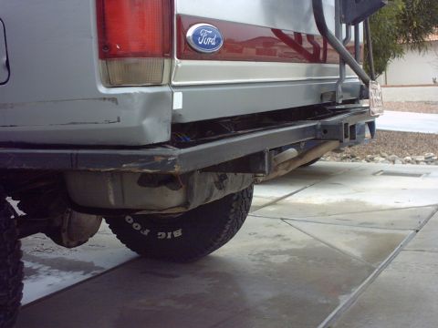 1990 Ford Bronco - The rear of a 1990 Ford Bronco is visible, a custom bumper and a tire with prominent lettering.