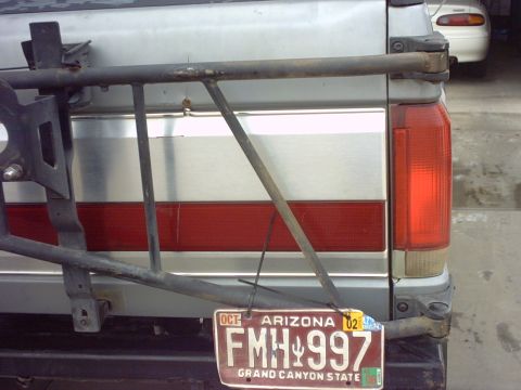 1990 Ford Bronco - The rear of a silver SUV is shown, a spare tire carrier and an Arizona license plate.
