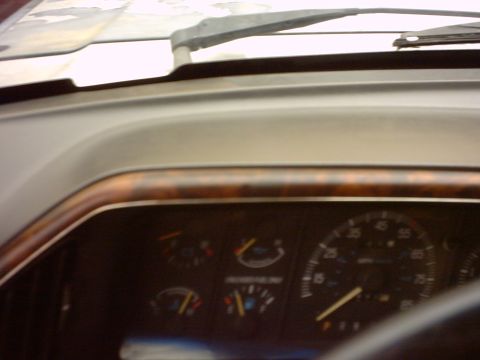 1990 Ford Bronco - Interior view of a 1990 Ford Bronco, showing the dashboard with wood grain trim and instrument cluster.