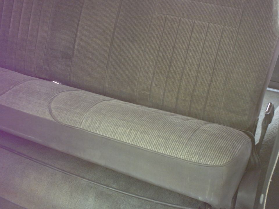 Gray fabric car seat with dark gray vinyl trim and vertical stitching on the seat back