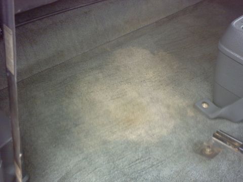 1990 Ford Bronco - The interior carpet shows some staining, with a portion of the gray plastic console visible on the right side.