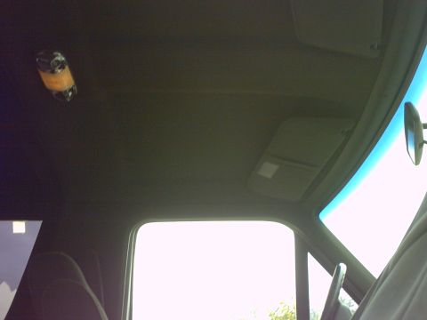 1990 Ford Bronco - Interior view of vehicle ceiling with sun visors and a hanging object.
