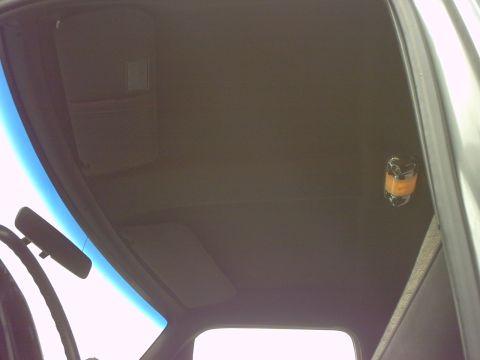 1990 Ford Bronco - The interior ceiling of a vehicle is shown, with a sun visor and rearview mirror in view.