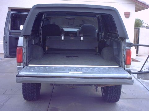 1990 Ford Bronco - Rear view of a gray Ford Bronco, revealing its spacious interior and folded rear seats.