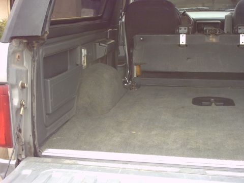 1990 Ford Bronco - Rear cargo area of a 1990 Ford Bronco with seats folded.