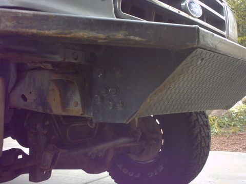 1990 Ford Bronco - Close-up view of the front bumper and tire of a 1990 Ford Bronco, showing custom diamond plate detailing.