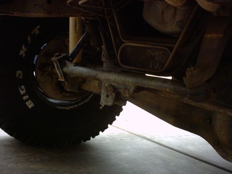1990 Ford Bronco - Close-up of vehicle undercarriage with visible tire and suspension parts.